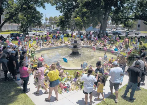  ?? JAE C. HONG/AP ?? People gather at a memorial honoring the victims of last week’s school shooting on Saturday in Uvalde, Texas.