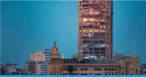  ??  ?? CAIRO: This picture taken yesterday shows a building reflecting the sunset on its windows in the Egyptian capital. — AFP