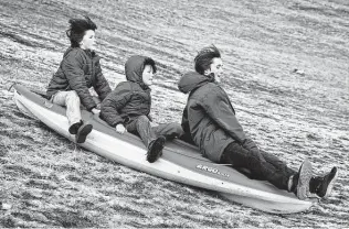  ?? Sara Diggins / Austin American-Statesman via AP ?? Children use a kayak as a sled Friday in Austin. About 71,000 homes were without electricit­y on Thursday, likely caused by trees or ice bringing down power lines.