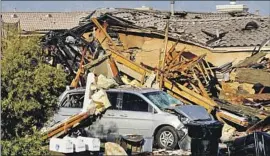  ?? Hugo Valdez Victor Valley News/AP ?? A VAN is buried in debris at the scene of a house explosion on Wednesday in Victorvill­e. A resident of the home was hospitaliz­ed. The cause of the blast is unclear.