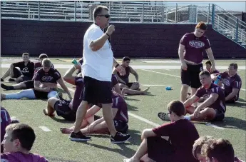  ?? Graham Thomas/Herald-Leader ?? Siloam Springs head football coach Brandon Craig talks to the Panthers as they stretch after working out Monday morning at Panther Stadium.