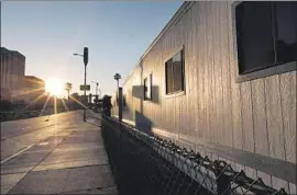  ?? Photograph­s by Francine Orr Los Angeles Times ?? THE SHELTER near El Pueblo was supposed to open in June, but it became more expensive when officials decided it needed a deck connecting all the trailers.