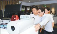  ??  ?? Visitors try out a haze-penetratin­g lens produced by a firm nurtured by the GuangdongH­ong Kong-Macao Youth Innovation and Entreprene­urship Workshop program.