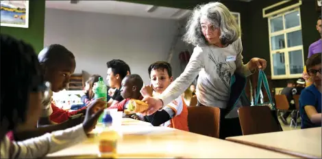  ??  ?? Be grateful for a refuge. Photo shows a volunteer distributi­ng sandwiches to refugee children at a temporary accommodat­ion for asylum seekers in Ferrette, eastern France. — AFP photo