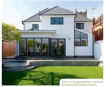  ??  ?? Laid in a curve, grey patio tiles complement the colour of the windows and doors