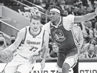  ?? TONY GUTIERREZ/AP ?? Dallas’ Luka Doncic works to get past Golden State’s Kevon Looney on March 3. The Mavericks won 122-113.