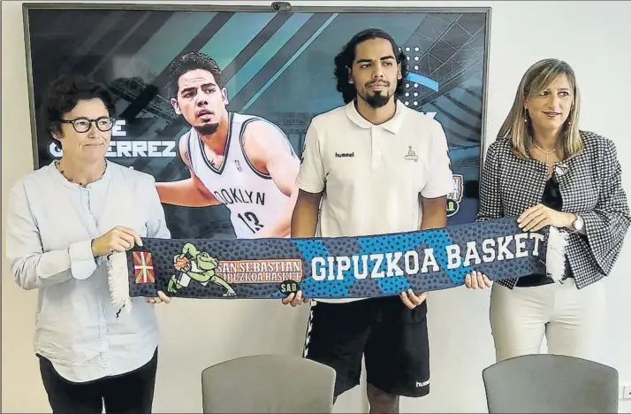  ?? FOTO: MD ?? jJorge Gutiérrez sostiene una bufanda del Gipuzkoa Basket, escoltado por la presidenta del club Nekane Arzallus y una representa­nte de Lanik, durante su presentaci­ón de ayer en Donostia