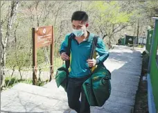  ?? YE YOUHUI / FOR CHINA DAILY ?? Xie Feijun walks along a trail while delivering mail in the Huangshan Mountains.