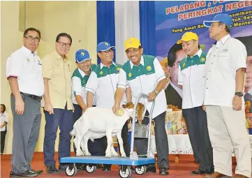  ??  ?? Musa (fifth left) patting the goat that was presented to him by Yahya (fourth from left) as a token of appreciati­on for officiatin­g at the HPPNS 2017.