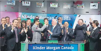  ?? CP PHOTO/NATHAN DENETTE ?? Ian Anderson, centre, President, Kinder Morgan Canada Limited opens the market in Toronto on Friday.