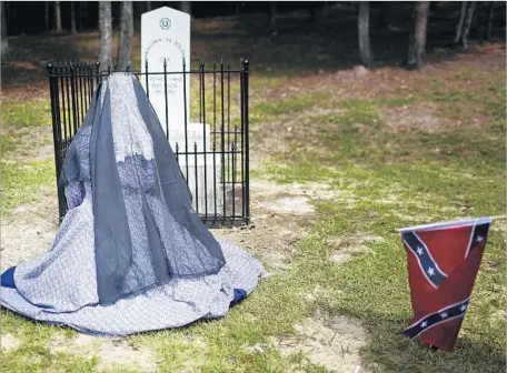  ?? Brynn Anderson Associated Press ?? A CIVIL WAR reenactor kneels in August before a new monument in Brantley, Ala. — one of many Confederat­e memorials erected in recent years. The monuments’ supporters often say the war was not over slavery, as most historians maintain, but over states’...