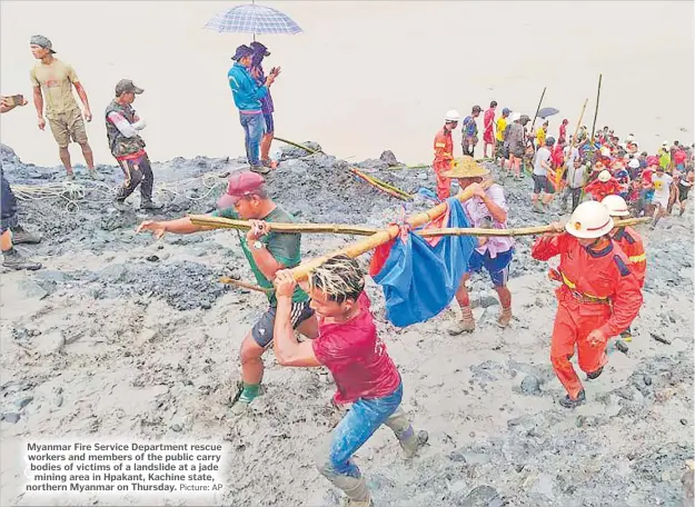  ?? Picture: AP ?? Myanmar Fire Service Department rescue workers and members of the public carry bodies of victims of a landslide at a jade mining area in Hpakant, Kachine state, northern Myanmar on Thursday.