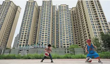  ?? ?? Flagging risks: Children playing in front of a housing complex by Chinese property developer Evergrande. The property-market meltdown has left investors in the world’s second-largest
credit market craving credible research to distinguis­h good debt from bad. - AFP
