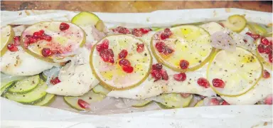  ?? MELISSA D’ARABIAN VIA AP ?? Cod with zucchini and pomegranat­e, prepared with papilotte method, is almost impossible to overcook.