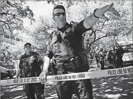  ?? [TAMIR KALIFA/AUSTIN AMERICAN-STATESMAN] ?? Law enforcemen­t officers secure the scene after a student stabbed several people Monday on the University of Texas campus in Austin.