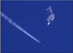  ?? CHAD FISH VIA AP, FILE ?? The remnants of a large balloon drift above the Atlantic Ocean, just off the coast of South Carolina, with a fighter jet and its contrail seen below it, Feb. 4.