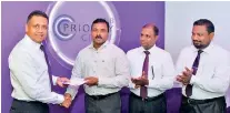  ??  ?? HNB Deputy General Manager Retail and SME Banking Thimal Perera accepts the first deposit from Sivakumara­n Nandakumar­an in the presence of Head of Private Banking S. Nandakumar and Jaffna Customer Centre Manager Vathulan Ganeshan