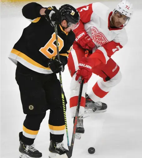  ?? CHRIS CHRISTO / HERALD STAFF ?? RED AND WHITE TRAFFIC CONE: Brad Marchand stick handles around Detroit's Andreas Athanasiou to set up David Pastrnak's goal in third period.