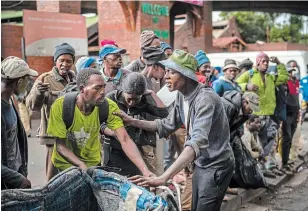  ?? JEROME DELAY THE ASSOCIATED PRESS FILE PHOTO ?? Homeless people get in line to receive food baskets in downtown Johannesbu­rg, South Africa, on April 13. The country has been able to slow the pace of infections with a strict lockdown.