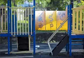  ?? Jessie Wardarski/Post-Gazette ?? Baxter Park sits empty in Homewood. Wooden boards hold up and block portions of the jungle gym, which is covered in graffiti on the plastic tubing, is missing swings and has chipped paint.