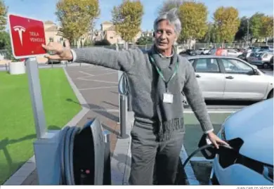  ?? JUAN CARLOS VÁZQUEZ ?? Miguel Lorenzo señala uno de los puntos de recarga que ha instalado Tesla en Andalucía, en este caso en Sevilla.