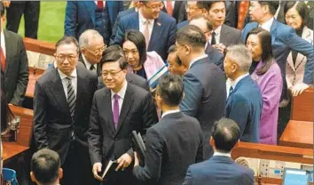  ?? Chan Long Hei Bloomberg ?? HONG KONG Chief Executive John Lee, center, shown at the Legislativ­e Council after the law’s approval, said, “Today is a historic moment.” It comes on top of a similar security law Beijing imposed in 2020.