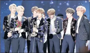 ??  ?? South Korean pop band BTS pick up an award