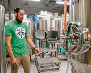  ?? KRISTINA WEBB / THE PALM BEACH POST ?? Royal Palm Brewing Co. co-owner and head brewer Geoffrey Shetka explains the brewing process in the company’s new Royal Palm Beach facility on Wednesday.