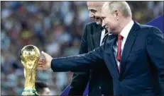  ?? Photo: AFP ?? Vladimir Putin (right) caresses the trophy next to FIFA president Gianni Infantino during the trophy ceremony at the end of the 2018 World Cup final in Russia.