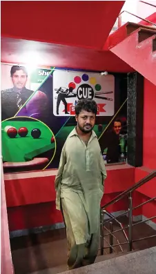  ??  ?? Muhammad Ikram arrives at a local snooker club in Samundri.