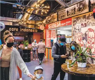  ?? ARIANA DREHSLER U-T ?? Customers check out the Market on 8th food hall in National City. The city changed its council election rules to create community districts, leading to the election of a Filipino American this month.