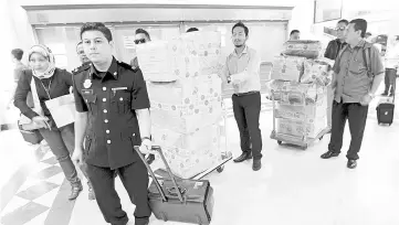  ??  ?? Malaysian Anti-Corruption Commission personnel moving the luxury watches and various types of jewellery to the Sessions Court as case exhibits. - Bernama photo