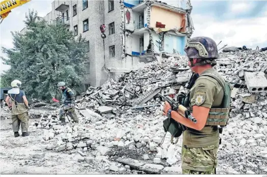  ?? EFE ?? Rescatista­s ucranianos buscan personas entre los escombros del edificio atacado en Chasiv Yar.