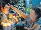  ?? AP FILE ?? Guadalupe Tadeo de Valenzuela prays to folk-saint Jesus Malverde to heal her sick daughter in Culiacan, Mexico. Malverde is also worshipped by many drug trafficker­s.