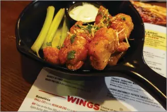  ?? MATT ROURKE — THE ASSOCIATED PRESS ?? A boneless chicken wing is not a wing at all in many food servings, often because of the price differenti­al.