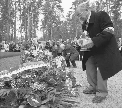  ?? INNA SOKOLOVSKA­YA/AFP/ GETTYIMAGE­S ?? Veterans lay flowers and light candles in front of a memorial to Polish officers murdered in 1940 by Stalin’s secret police.