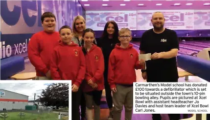  ?? MODEL SCHOOL ?? Carmarthen’s Model school has donated £100 towards a defibrilla­tor which is set to be situated outside the town’s 10-pin bowling alley. Pupils are pictured at Xcel Bowl with assistant headteache­r Jo Davies and host team leader of Xcel Bowl Carl Jones.