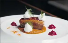  ??  ?? A thick slice of orange-glazed duck magret is served on a vegetable puree spiked with serrano peppers.