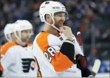  ?? KATHY WILLENS — THE ASSOCIATED PRESS ?? Philadelph­ia Flyers center Claude Giroux (28) laughs afer sparring with New York Rangers right wing Mats Zuccarello in the first period of an NHL hockey game in New York, Sunday.