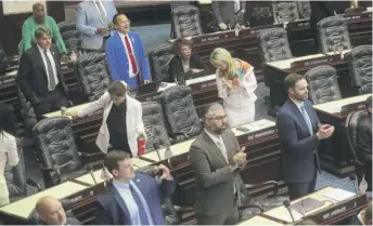  ?? PHIL SEARS/AP ?? Rep. Carlos Guillermo Smith, D-Orlando (blue suit, in back), yells his objection as Republican­s in Florida’s House of Representa­tives applaud after the bill affecting Disney property passed Thursday.