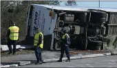  ?? MARK BAKER — THE ASSOCIATED PRESS ?? Police inspect a bus in its side near the town of Greta following a crash in the Hunter Valley, north of Sydney, Australia early Monday.