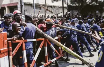  ?? Moses Sawasawa / Associated Press ?? Congolese police stop protesters in Goma from marching toward the border with Rwanda.