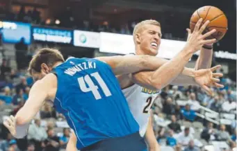  ?? Tony Gutierrez, The Associated Press ?? Dallas Mavericks forward Dirk Nowitzki fouls Mason Plumlee as the Nuggets center tries to make a pass during the first half Monday night.