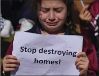  ?? (AP/Bilal Hussein) ?? A girl weeps as she holds a placard Tuesday during a protest against Israel’s attack on the Gaza Strip, in front of the headquarte­rs of U.N. Economic and Social Commission for Western Asia (ESCWA) in Beirut, Lebanon.