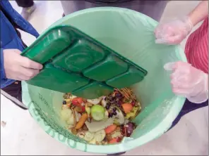  ?? The Associated Press ?? Students discard food at the end of their lunch period as part of a lunch waste composting program at an elementary school in Connecticu­t.