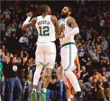  ??  ?? Boston Celtics guards Terry Rozier (left) and Kyrie Irving jump in the air in celebratio­n of a basket during their NBA game against Houston Rockets on Thursday.