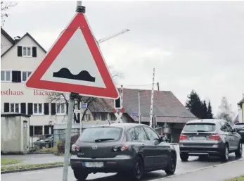  ?? FOTO: ROLAND WEISS ?? Vorsicht Kuppe – ein Schild weist am Bahnüberga­ng in Kehlen darauf hin. Und mahnt zugleich, dass sich hier baulich noch etwas tun muss, ja schon längst tun müsste.