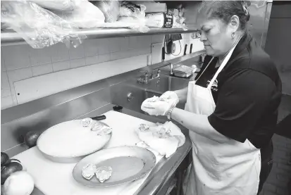  ?? PAUL W. GILLESPIE/CAPITAL GAZETTE PHOTOS ?? O’Brien’s Oyster Bar and Seafood pantry chef Angie Tobias shucks Skipjack oysters.