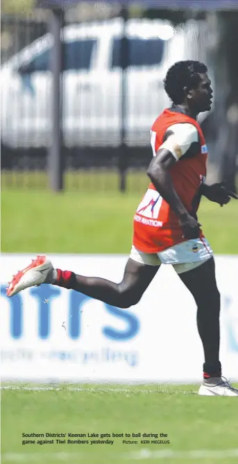  ?? Picture: KERI MEGELUS ?? Southern Districts’ Keenan Lake gets boot to ball during the game against Tiwi Bombers yesterday