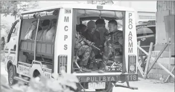  ??  ?? Suspected self-styled IS group members are transporte­d in a police vehicle after being captured in a village in Marawi City. — AFP photo